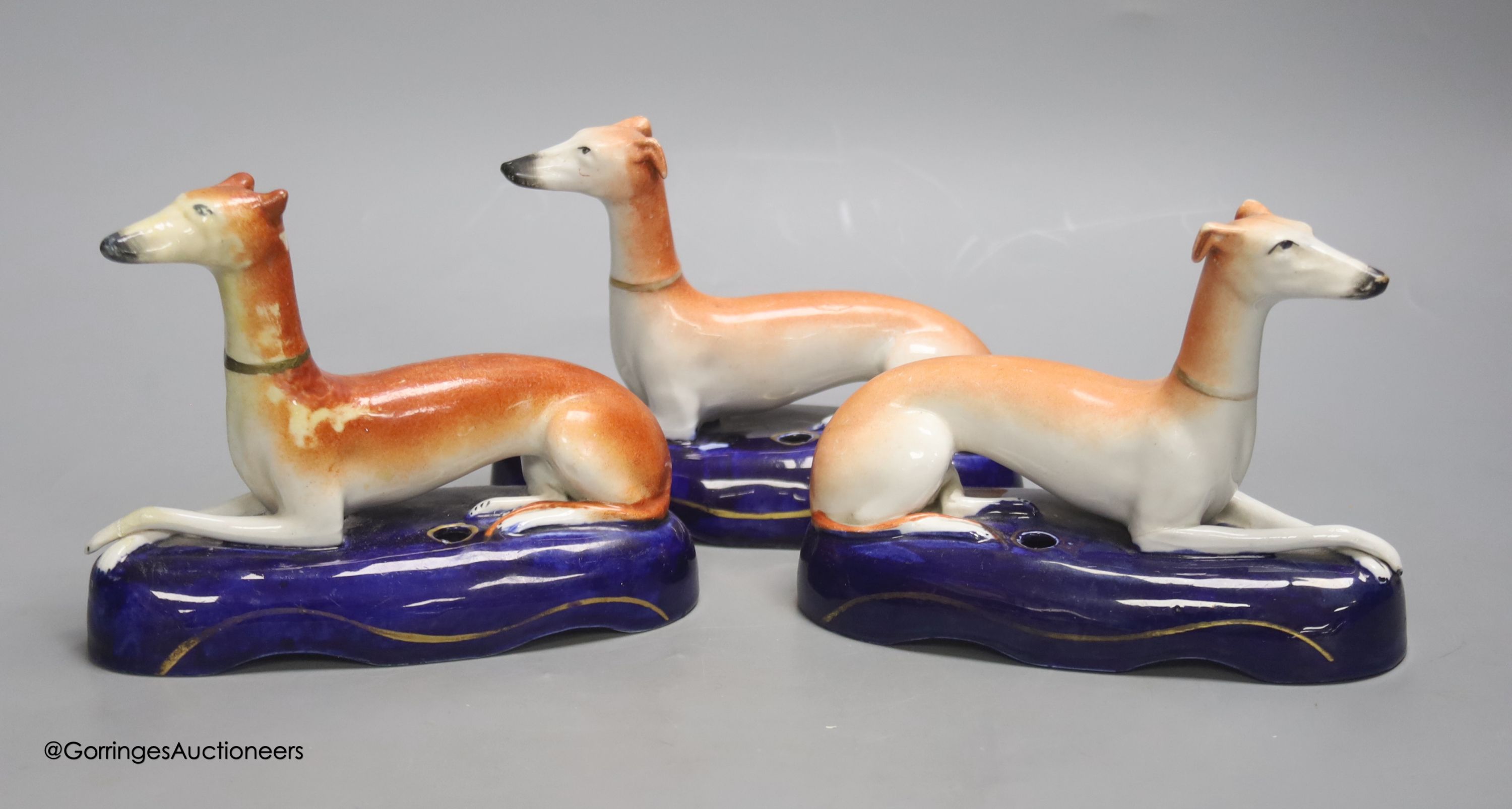 A pair of Staffordshire greyhounds and another similar, tallest 12cm